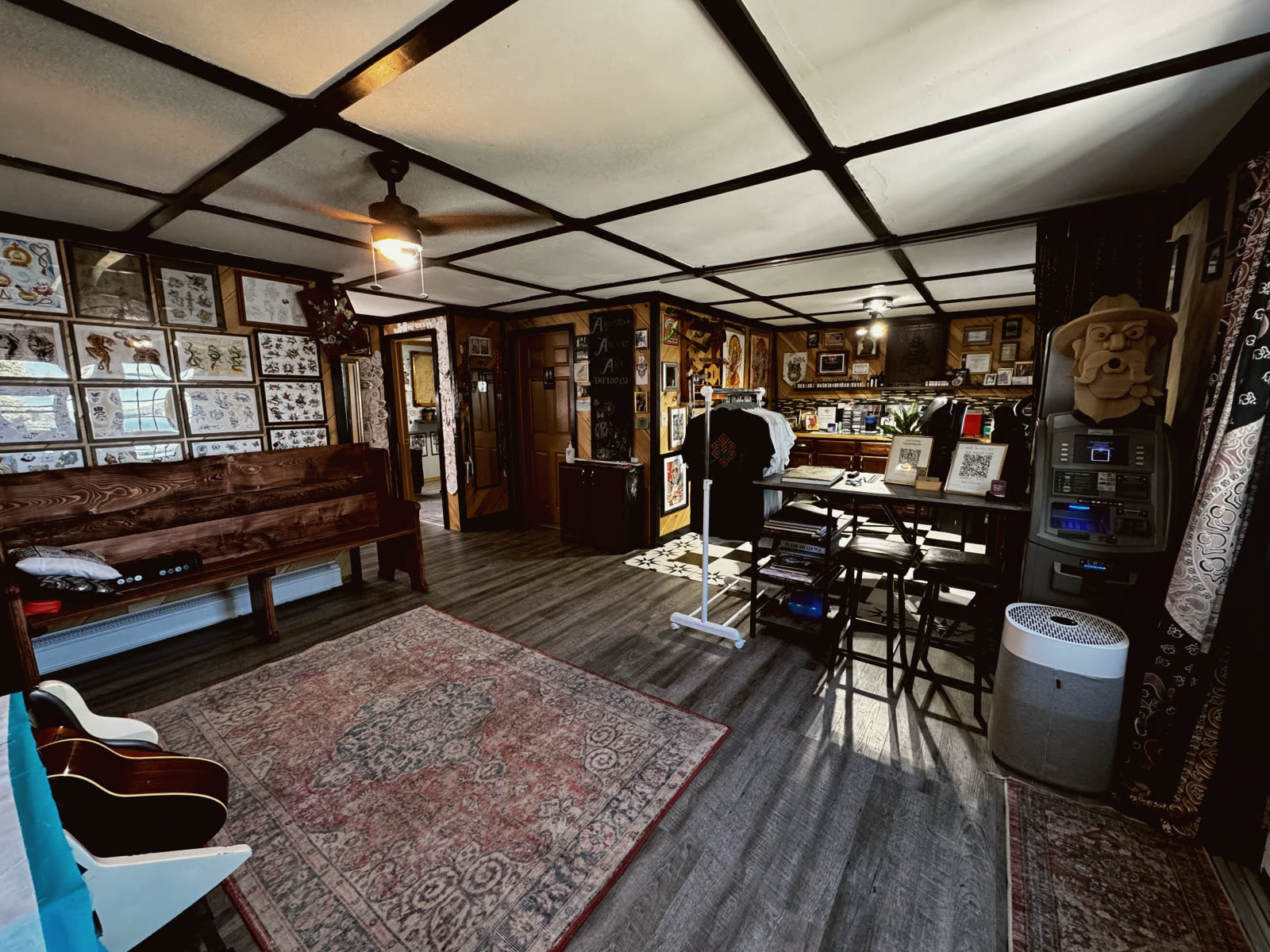 The front room of Aroostook Ancient Art Tattoo Co. in Sinclair, Maine, walls covered in framed flash